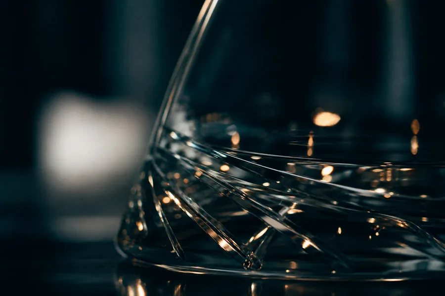 An abstract macro of dark glass with refracted points of warm light